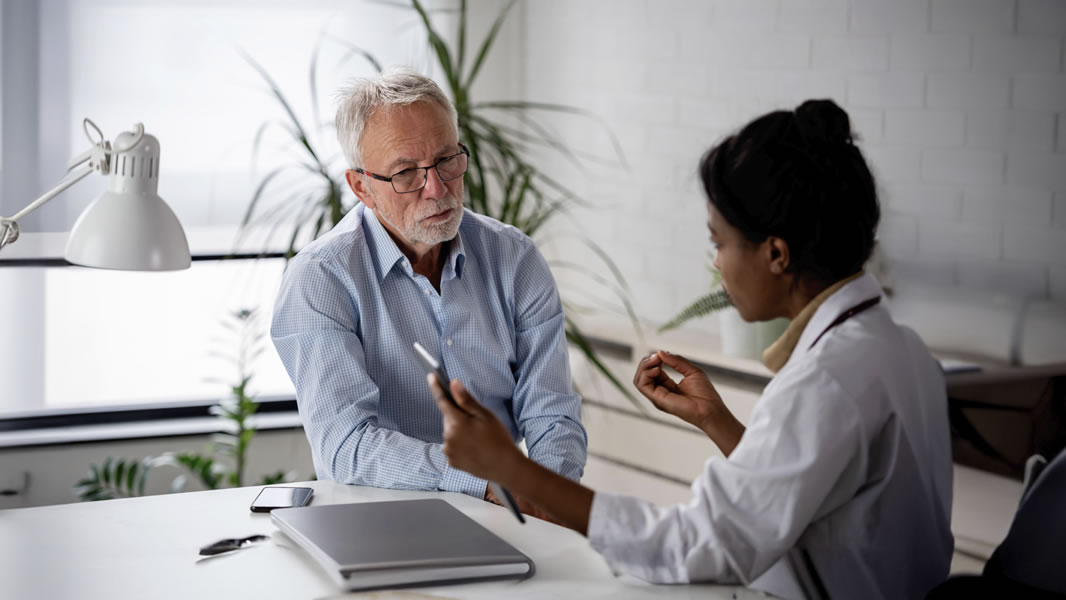 An HCP speaks to an older adult patient